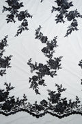 Schwarze Tüllspitze L25-017BLK mit Blumenstickerei und geschwungener Bordüre.