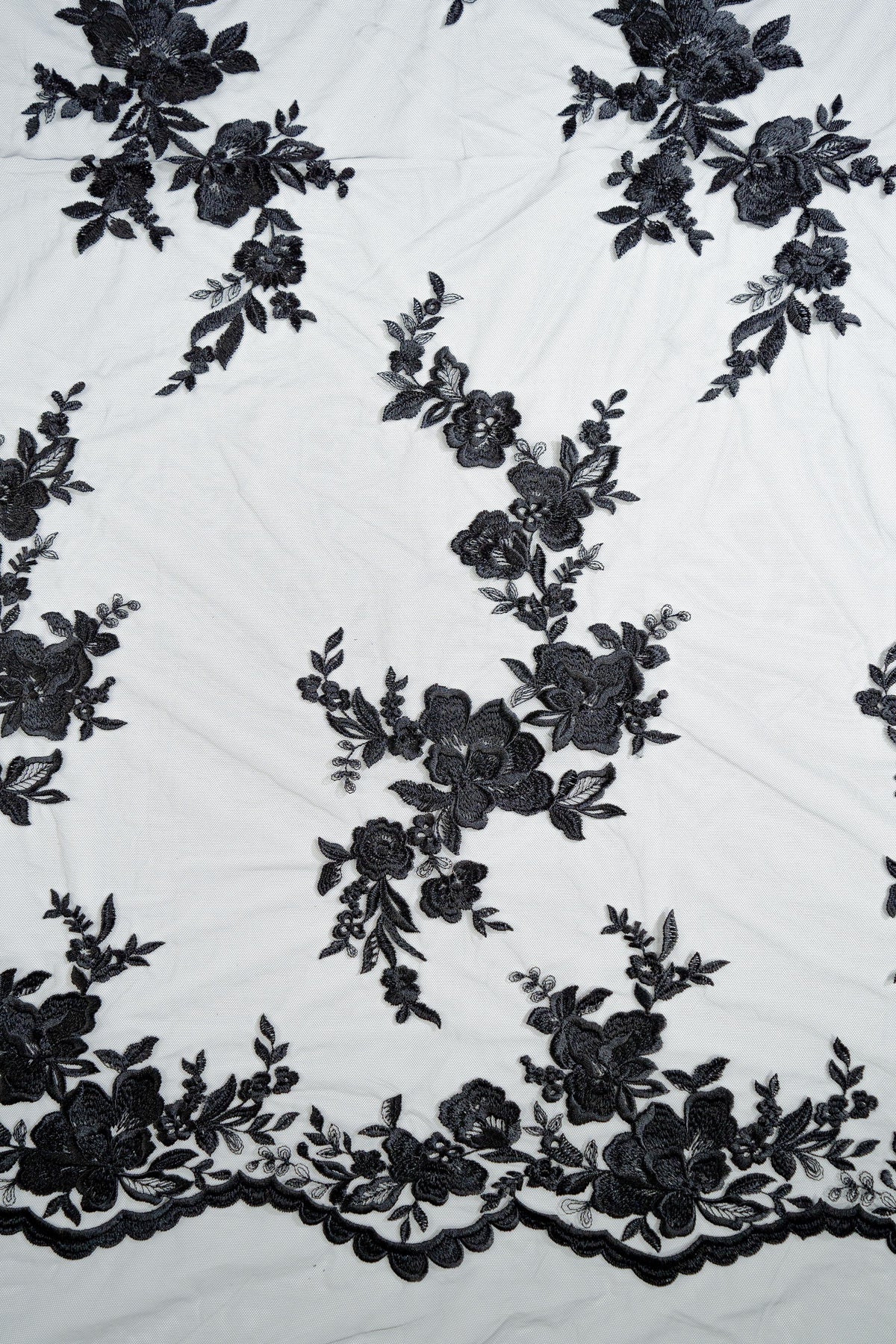 Schwarze Tüllspitze L25-017BLK mit Blumenstickerei und geschwungener Bordüre.
