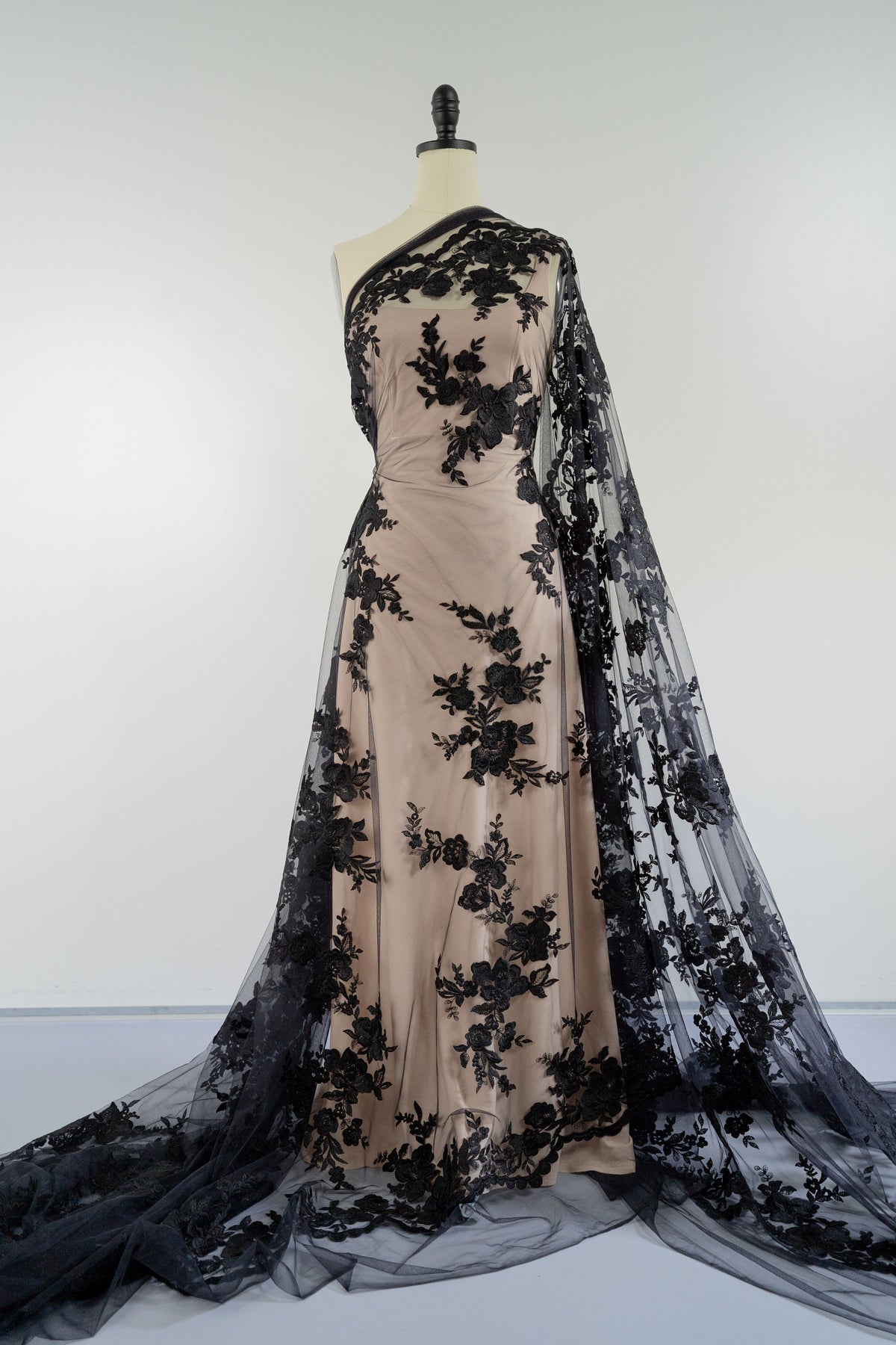 Schwarze florale Tüllspitze L25-017BLK in voller Länge auf einer Schneiderpuppe.