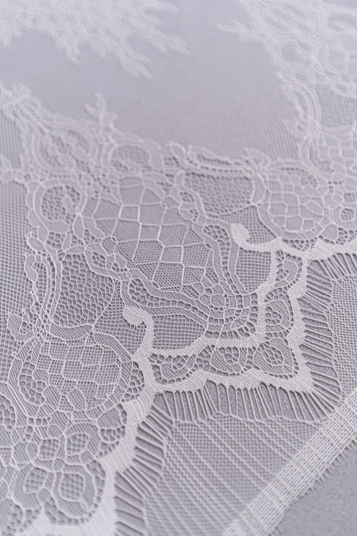 Nahaufnahme der Ornamentstickerei von L26-034B in Off-White.
